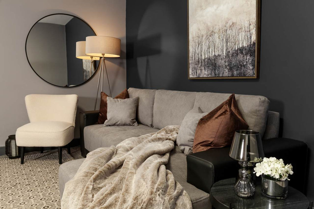 elegant looking sofa bed with pillows and mirror at the wall