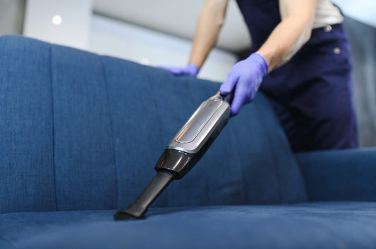 house keeper cleaning a blue colored sofa