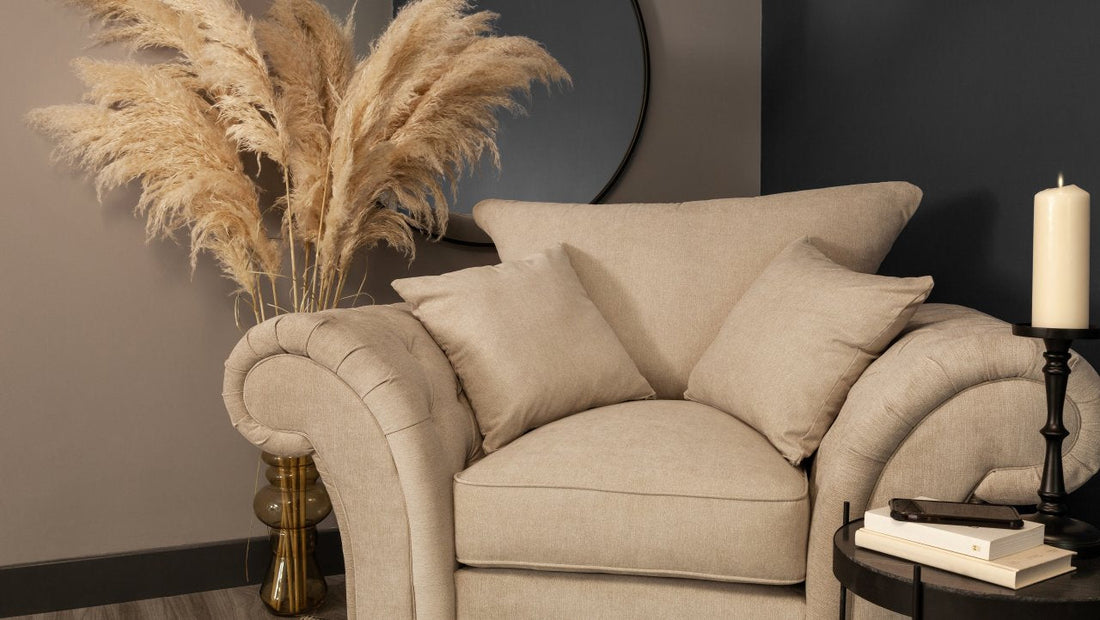 cream colored armchair with coffee table and books